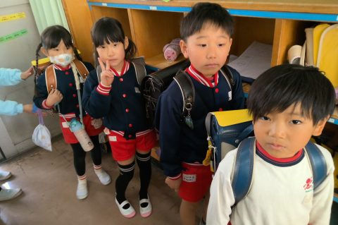 ランドセルを背負った子供達、並んで歩く。11月【年中】今週の様子、教室で、笑顔なし。