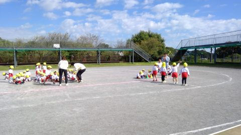 園庭で遊ぶ子供たち。先生と一緒。12月【年少】今週の様子。晴天の青空の下。