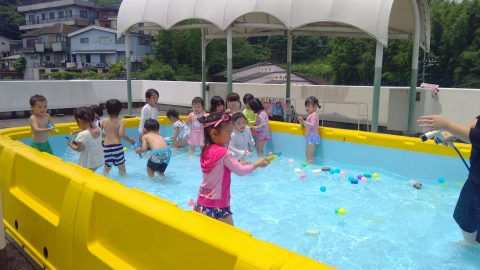 子供たちがプールで遊んでいます 3月【年長】ピクニックランチ・外遊び 夏の暑い日に水遊びをする