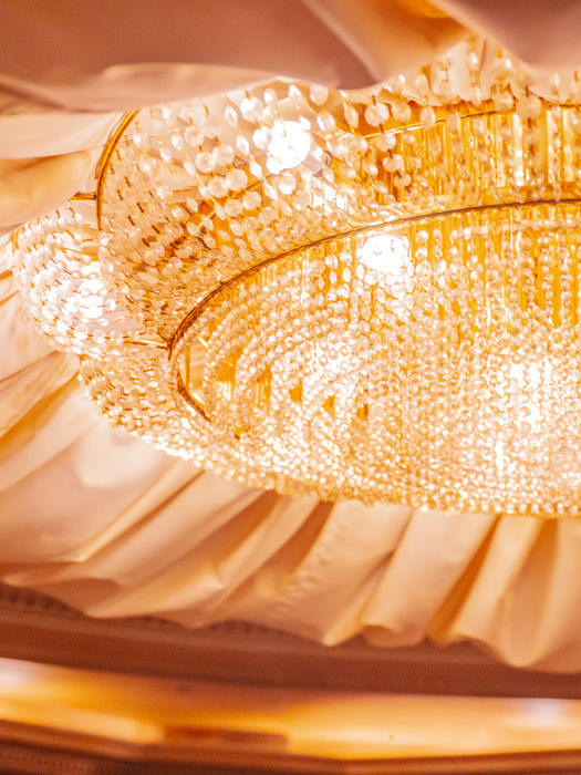 豪華なシャンデリアと天井の装飾。明るく輝く光が美しい。店舗情報。贅沢な雰囲気。