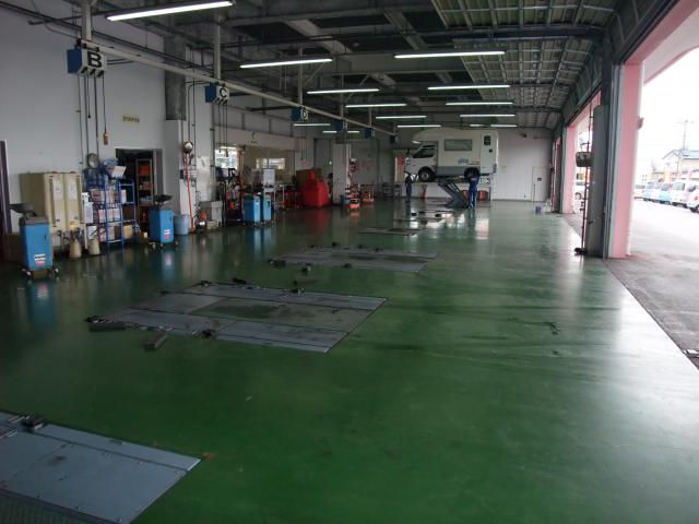 車がリフトアップされた整備工場