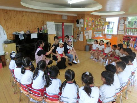 先生と子供たち、座って話しています。子供たちと先生たち、幼稚園の教室。