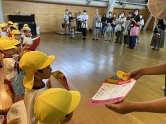 園児と保護者に向かって、賞状を渡しています。12月【年少】大掃除行事。イベント。