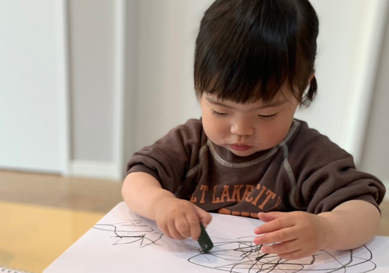 テーブルでクレヨンで絵を描く子供たち