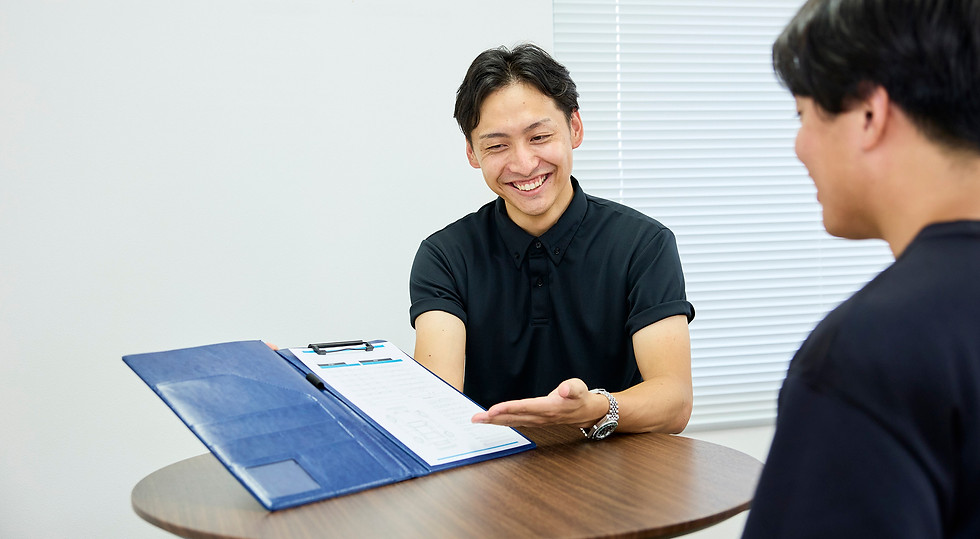 雹害車の修理の見積もりを提案している男性従業員