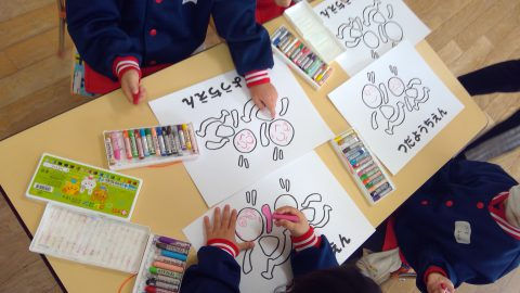 子供たちがクレヨンで絵を描いています。「つだうらえん」の文字とイラスト。12月【年少】大掃除