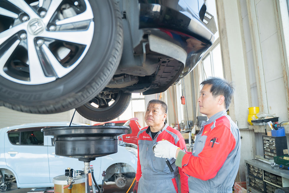 整備士が車の点検中、オイル交換 トップ 車の下で作業する様子