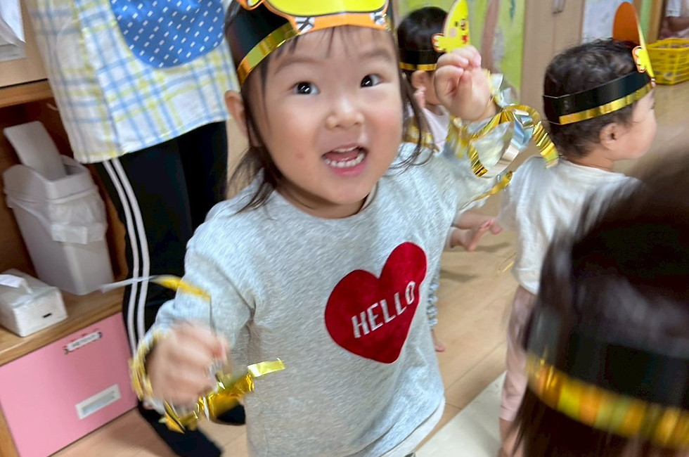 黄色いひよこの帽子をかぶって笑う子供