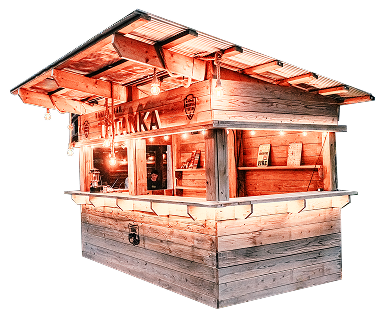 TATANKAのロゴが入った、温かみのある照明に照らされた木製の屋外売店