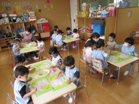 保育園の子供達がスタンプ遊び中。先生たちも見守る。6月【年少々】スタンプ遊び、楽しそう。