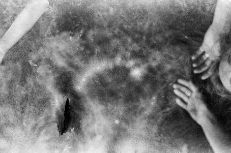 film picture of two hands against murky, dark background