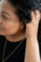 woman holding back hair, showing teardrop stud earrings