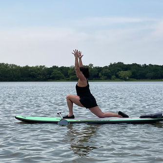 Yoga student on a paddle board doing a yoga pose.