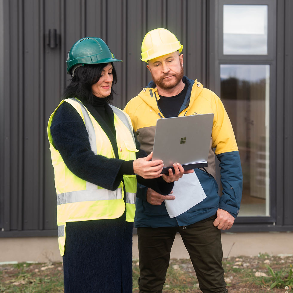 Kian Clements-Ormond reviewing home construction plans on site with Hedgley Corporation project manager in Christchurch, NZ