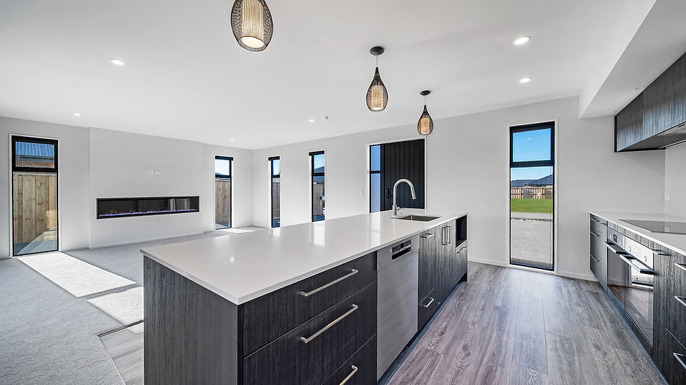 Spacious modern kitchen and open-plan living area built by Hedgley Corporation, featuring a large island bench, wood-grain cabinetry, pendant lights, and floor-to-ceiling windows.