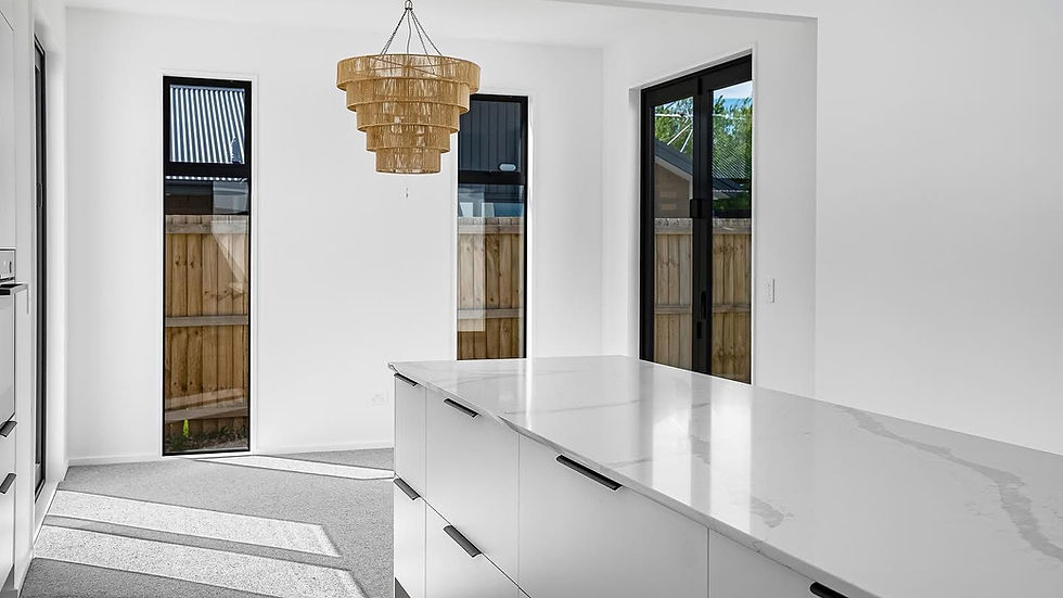 Bright and modern kitchen island with pendant chandelier in a new build by Kian Clements-Ormond
