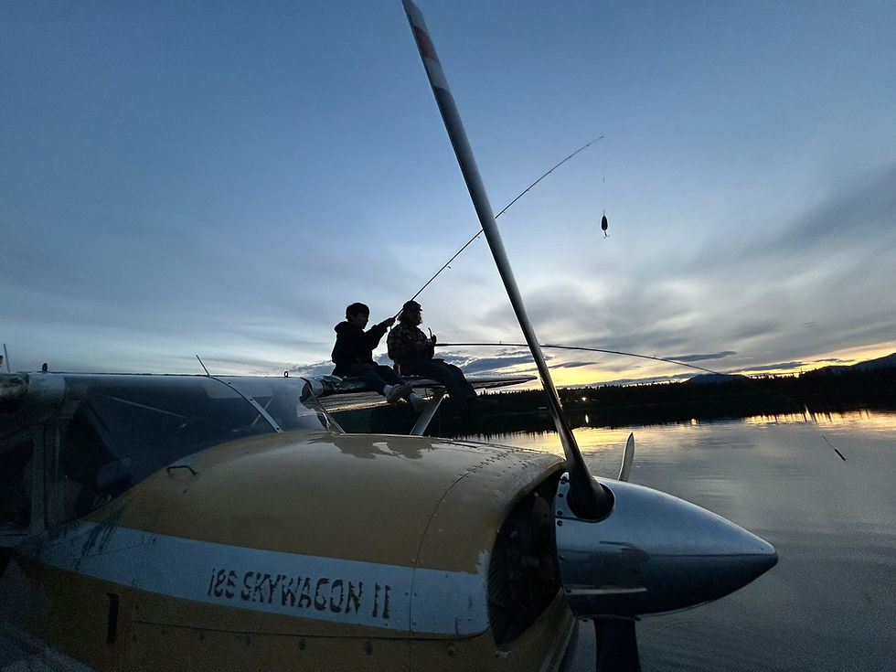 Man and boy fishing off the wing of a float plane