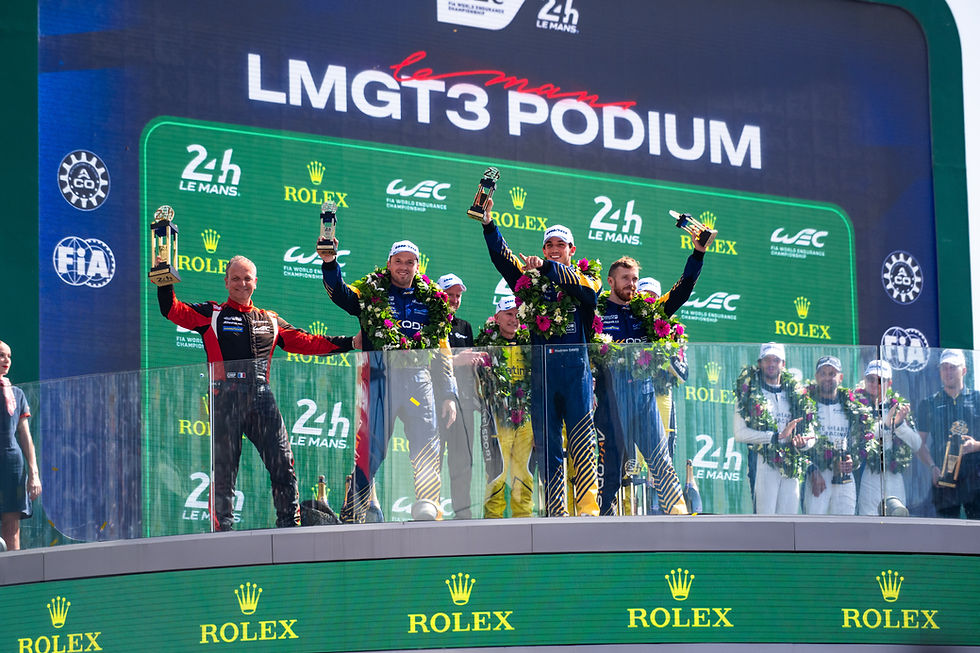 Le Mans LMGT3 podium: three drivers (Tom Van Rompuy, Hadrien David and Jack Hawksworth) in race suits and flower leis raise trophies | Credit: DPPI / Marius Hecker