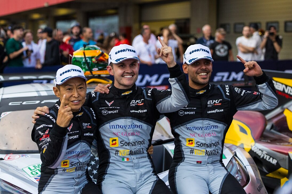 Three race car drivers sitting on the hood of a car celebrating their race win | Credit: Stephen Power