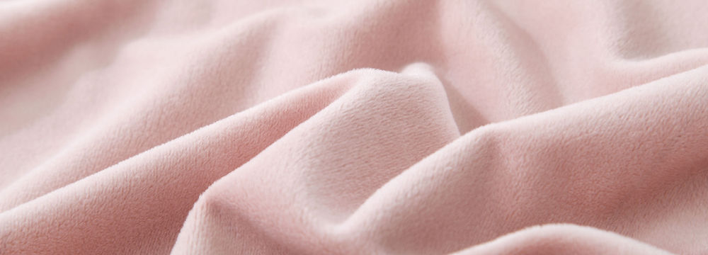 Close-up of soft pink velvet fabric with delicate folds and textures, delicate fabrics.