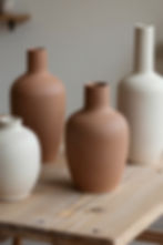 Earth-toned ceramic vases on a wooden table