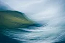 Abstract image with swirling blue and green hues, resembling a blurred landscape. It conveys a sense of motion and tranquility.