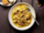 Creamy pappardelle pasta with herbs and bread.