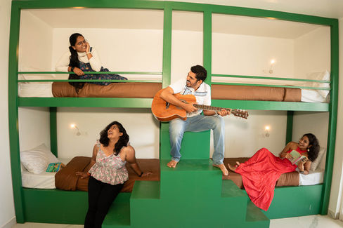 Hostel dorm with cheerful guests lounging on bunk beds
