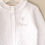Thumbnail: Personalised White Pebble Christening Cardigan with Gothic Cross close up