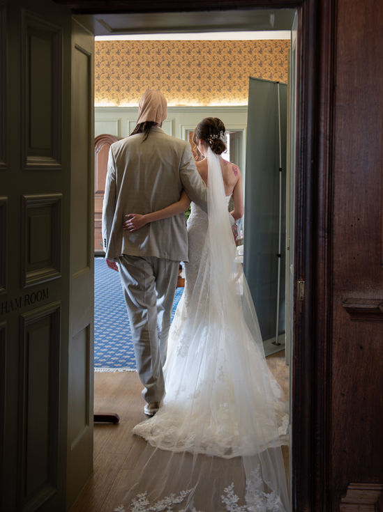 a bride and groom walk through a door that says ham room