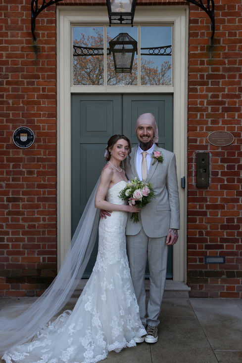 a bride and groom pose for a picture in front of a green door