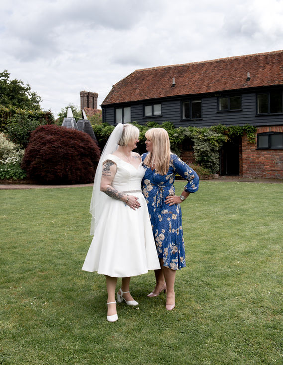 a woman in a blue dress stands next to a woman in a white dress