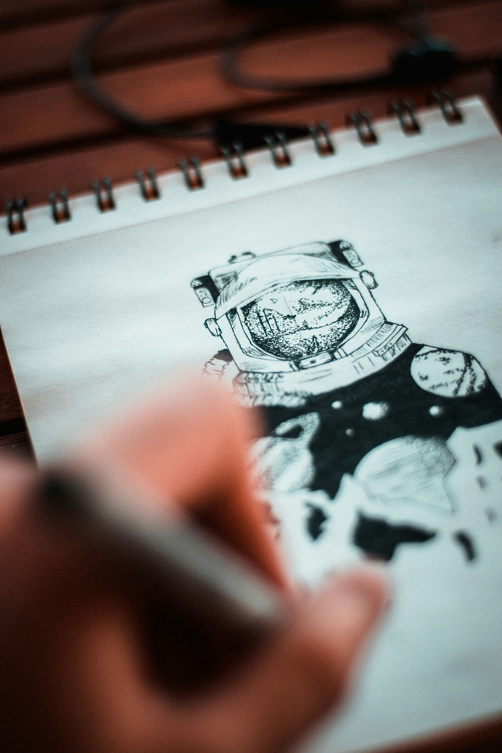 A student drawing and astronaut during an ink illustration class
