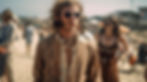 fair haired hippie man with cool 1960s glasses stairs into the distance, he is wearing a stylish hippie jacket and is on the beach with other hippies standing around him who are blurred out in the background