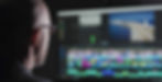 A Shootlab video editor wearing glasses and working on a video editing timeline displayed on a computer screen