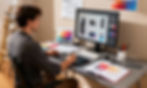 Designer working at computer station creating visual assets and product mockups for AI video advertisements.
