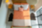 looking down on double bed with orange duvet cover Piglet bedding Drone photo