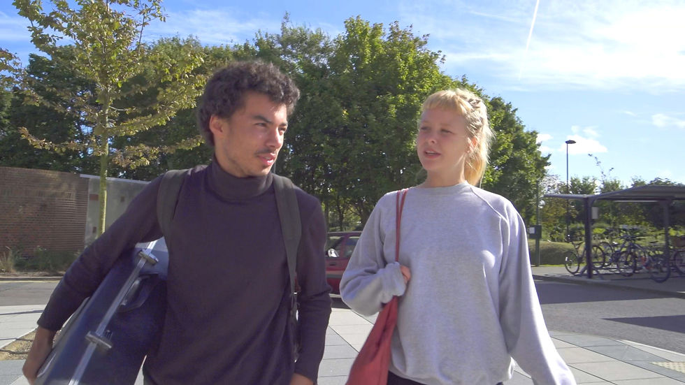 Two students walking and talking outside on a school campus, representing Shootlab's video production services for the education sector