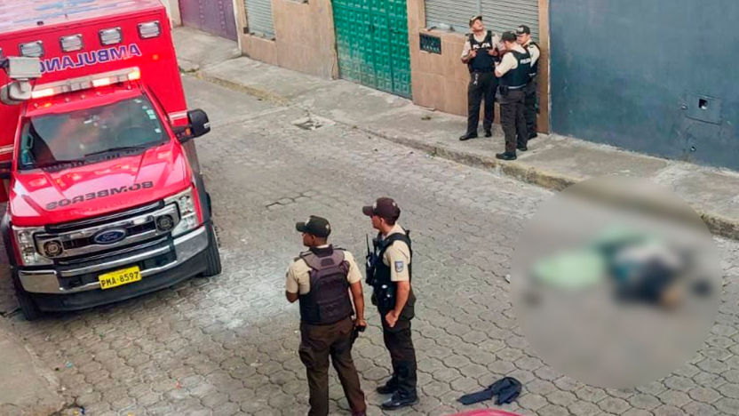 Agentes de la Policía Nacional junto al cuerpo sin vida de un sacapintas en Quito.