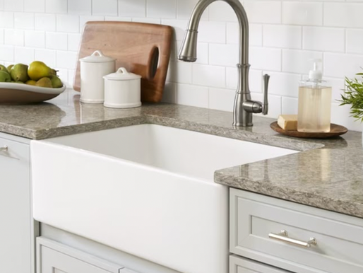 farmhouse sink with marble countertops and grey cabinetry