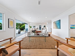 open-concept living room with open sliding doors leading out to patio overlooking the ocean