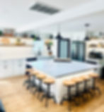 Kitchen with large island with six barstools