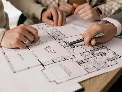 Hands hovering over building floor plans