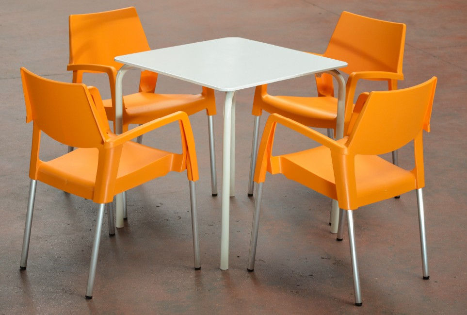 Miniatura: Mesa cuadrada blanca con cuatro sillas naranjas modernas.