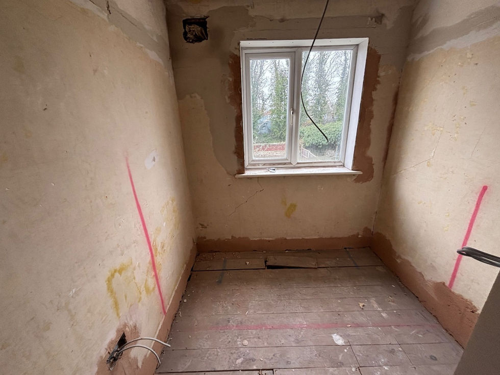 Room under renovation with stripped walls and wood floor