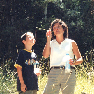 Mom and son outside near woods.