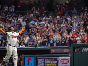 Baseball player Jose Ramirez in the field with his hands up.