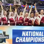 Oklahoma Women's Gymnastics team celebrating winning the NCAA title holding the trophy with confetti falling behind them.