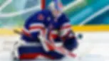 Athlete Aerin Frankel in her goalie gear at net, stopping a puck from getting into the net.