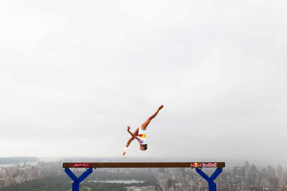 Athlete Lily Smith doing her beam routine 52 stories up with Manhattan in the background.